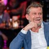 Andreas Guenther guckt lachend zur Seite, Hand am Kinn