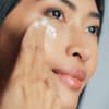 Asiatische Frau mit Augencreme