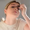 Frau benutzt Mascara