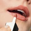 Frau trägt Lippenfarbe auf