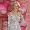 Susan Sideropoulos im weißen Glamour-Kleid, pinker Hintergrund