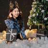Eine Frau sitzt vor dem Weihnachtsbaum