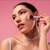 Frau trägt Blush mit Pinsel auf