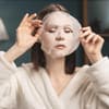 Frau legt Tuchmaske aufs Gesicht