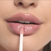 Frau trägt Lipgloss auf