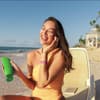 Frau cremt sich am Strand ein