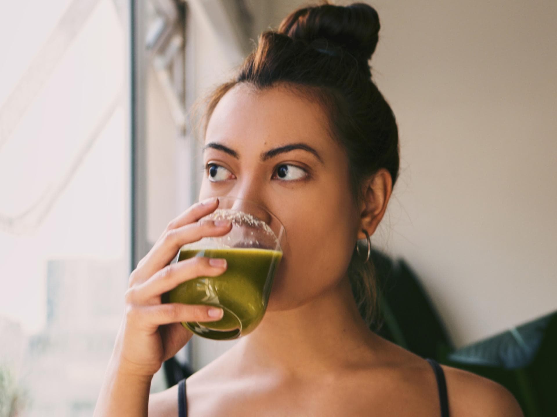 Frau trinkt grünen Drink