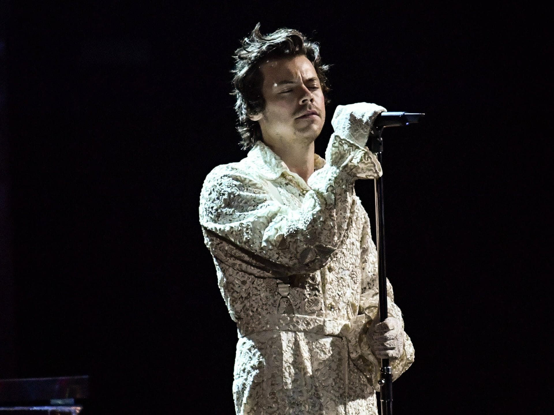 Harry Styles singt mit geschlossenen Augen im weißen Anzug bei den Brit Awards 2020