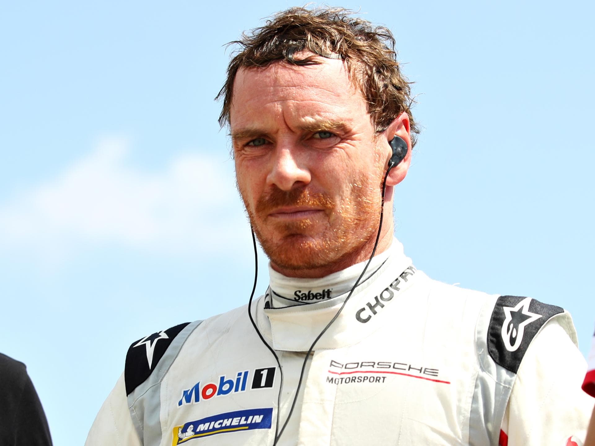 Michael Fassbender im Rennfahrer-Outfit beim Porsche Supercup