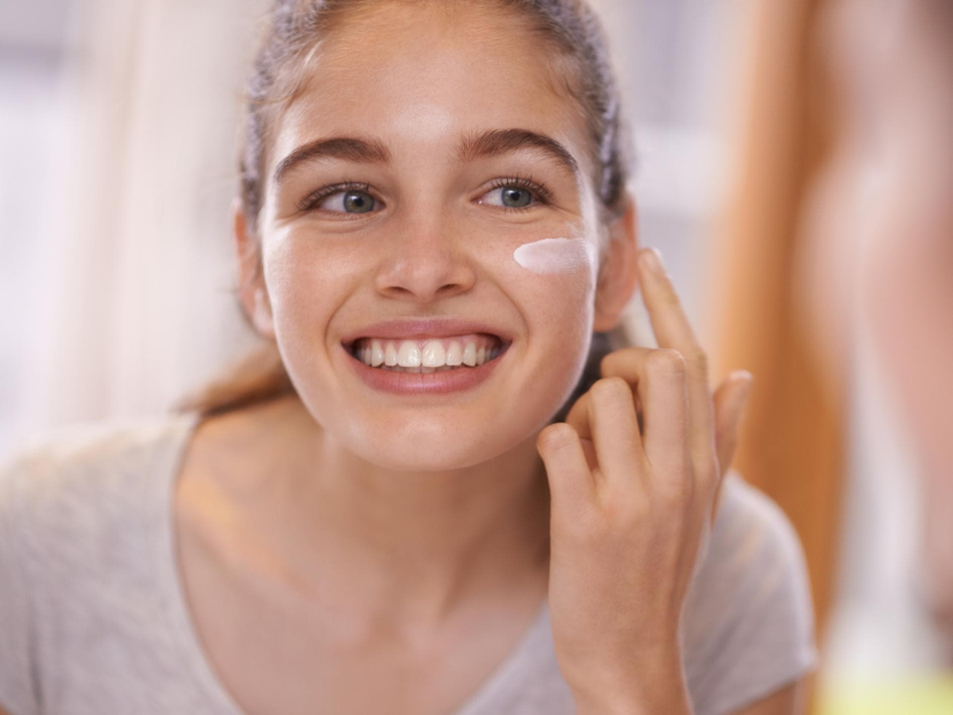Frau mit Anti-Aging-Creme gegen erste Falten