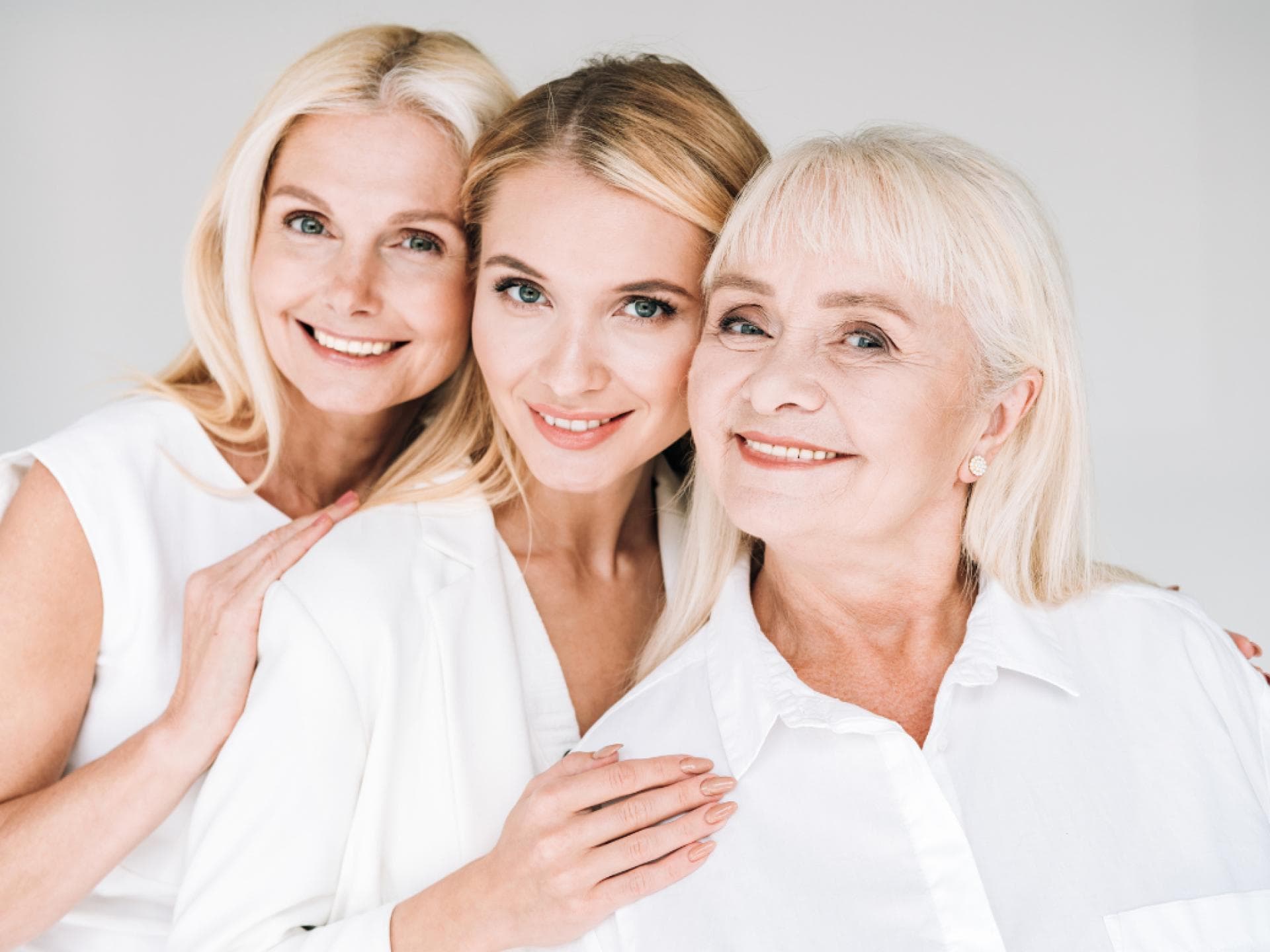 Anti-Aging-Pflege für jedes Alter Fröhliche drei Generation blonde Frauen isoliert auf grau