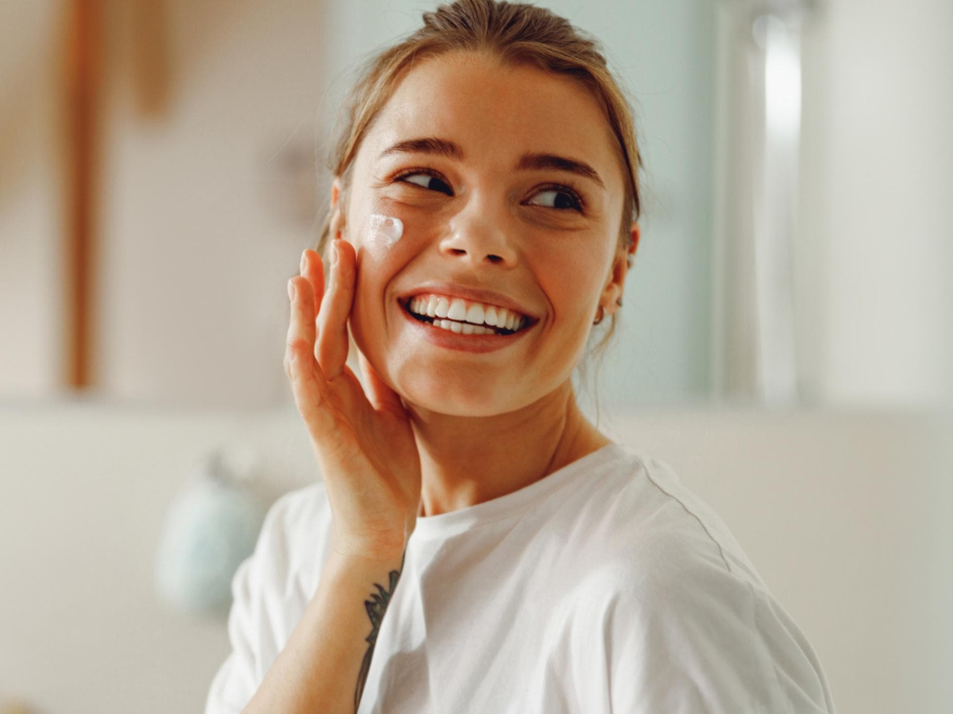 trockene Haut Anti-Aging-Creme Frau lächelt, Creme auf Wangen