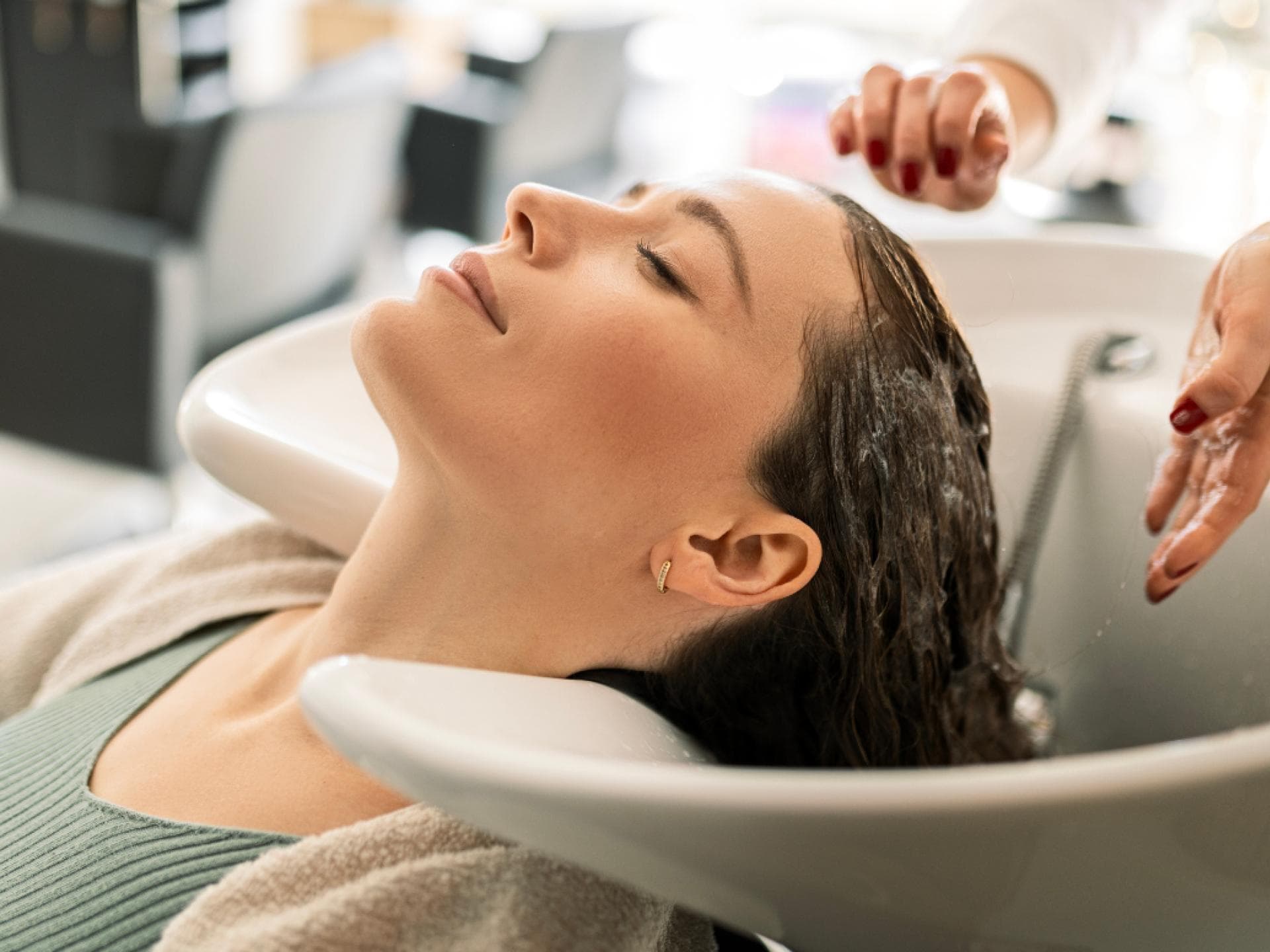 Conditioner gegen Haarausfall von Friseuren Frau im Waschbecken beim Friseur
