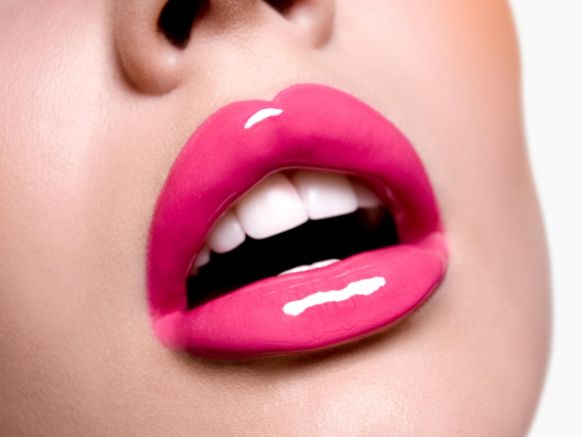Lipgloss für 400% mehr Glanz Frau mit knallpinken glänzenden Lippen