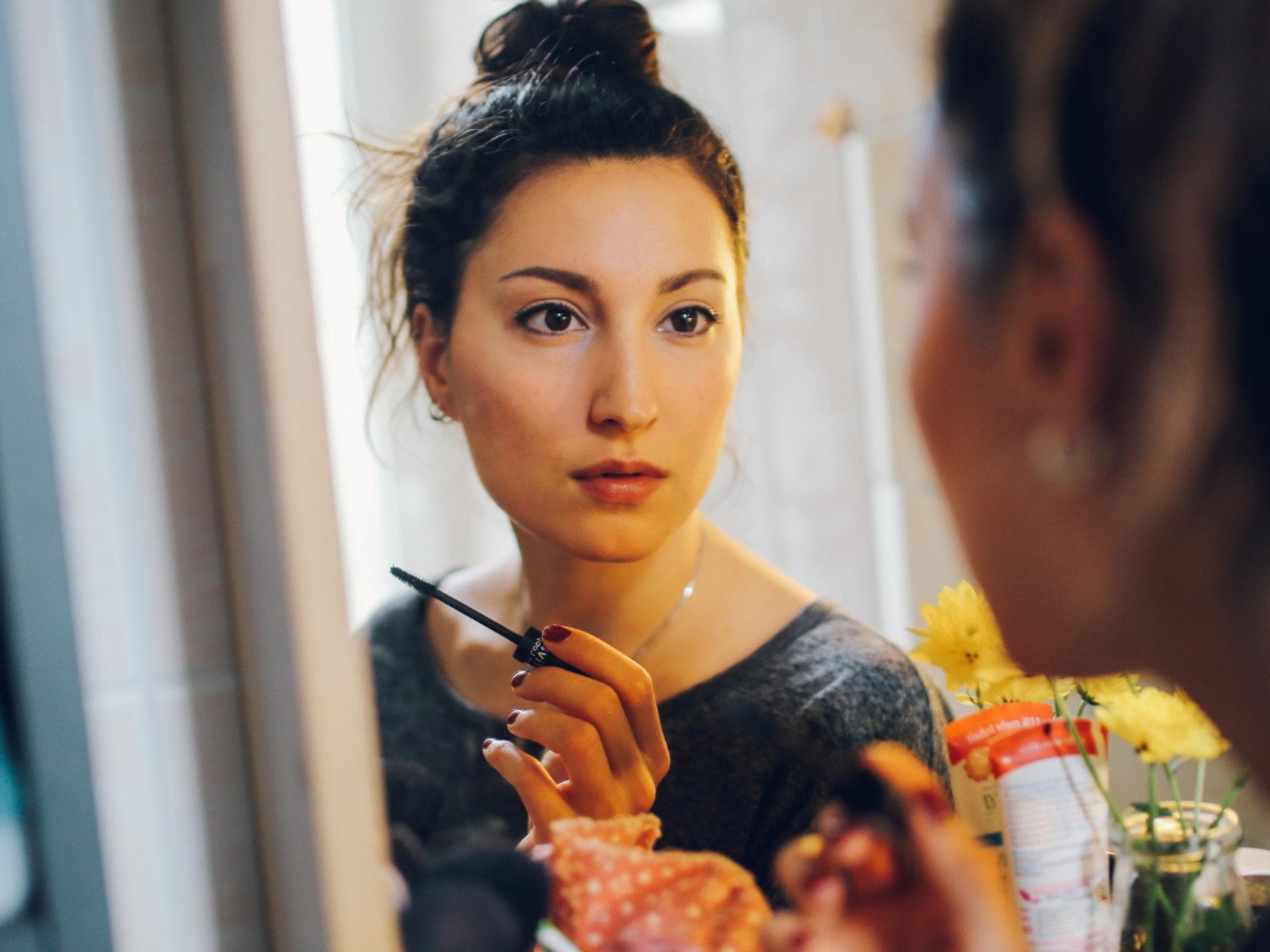 Prime Day Mascara-Rabatt Frau mit Mascara vor Spiegel