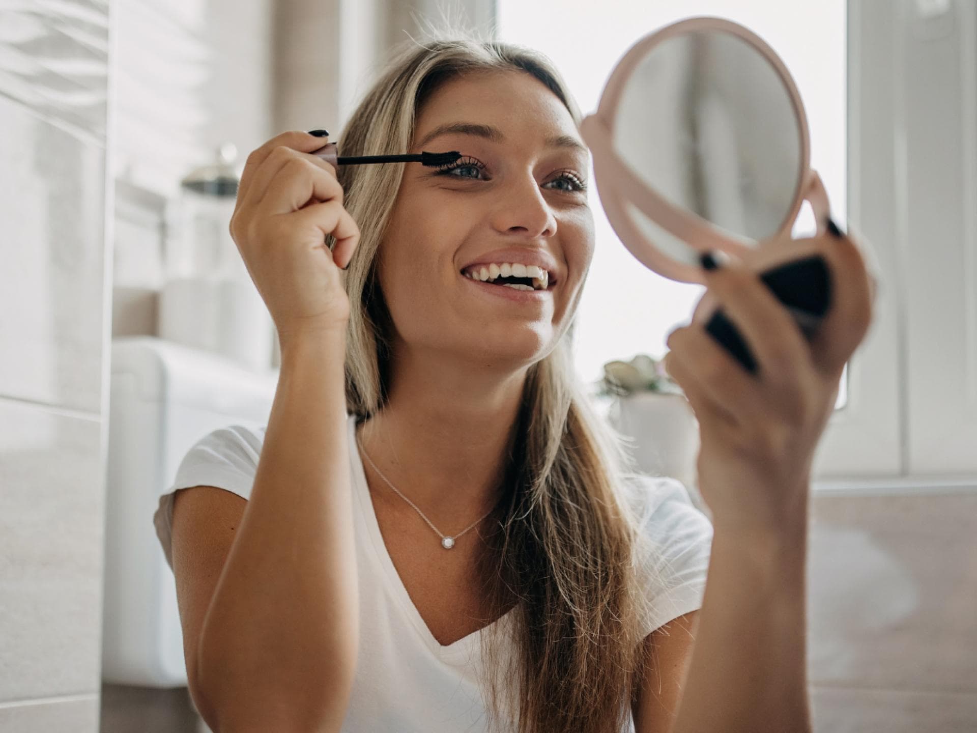 Mascara TikTok Frau mit Kosmetikspiegel Mascara