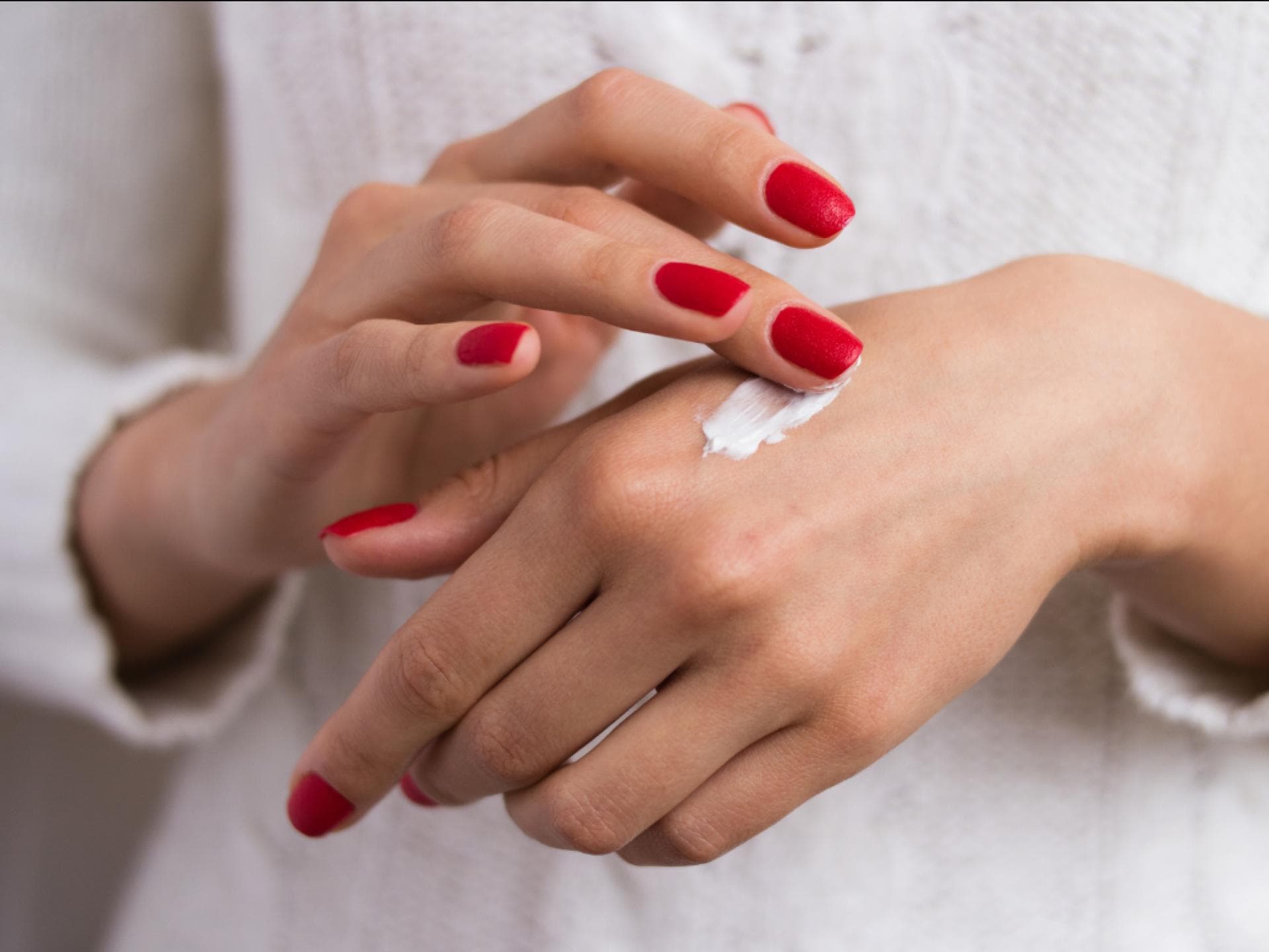 Handcreme von Hand-Model Frau creme Hände ein
