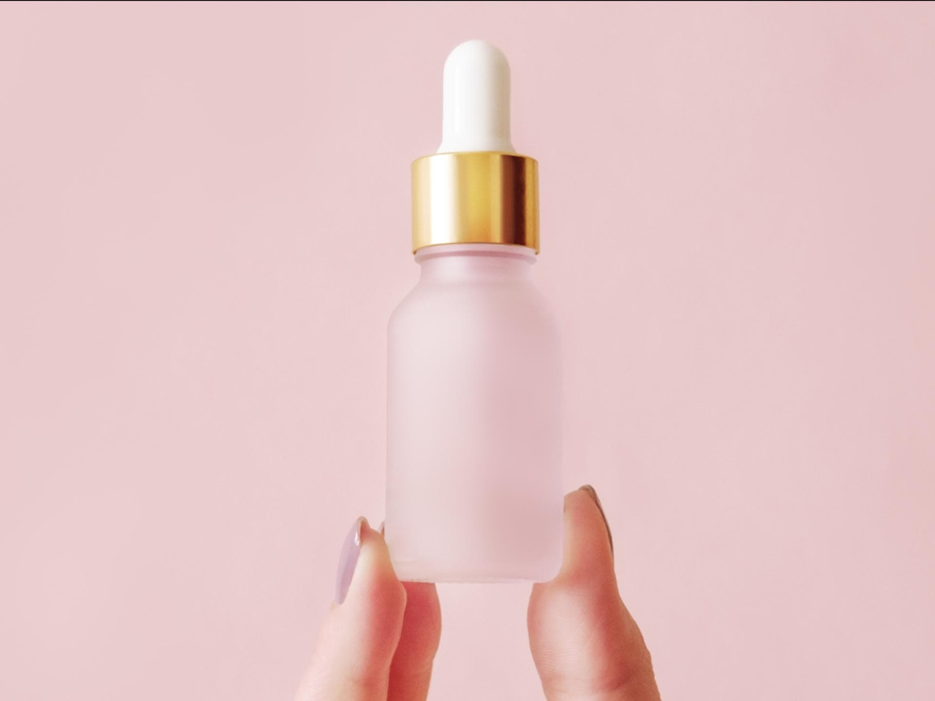 Hyaluron-Serum reduziert Frau mit Serum-Flasche zwischen Finge