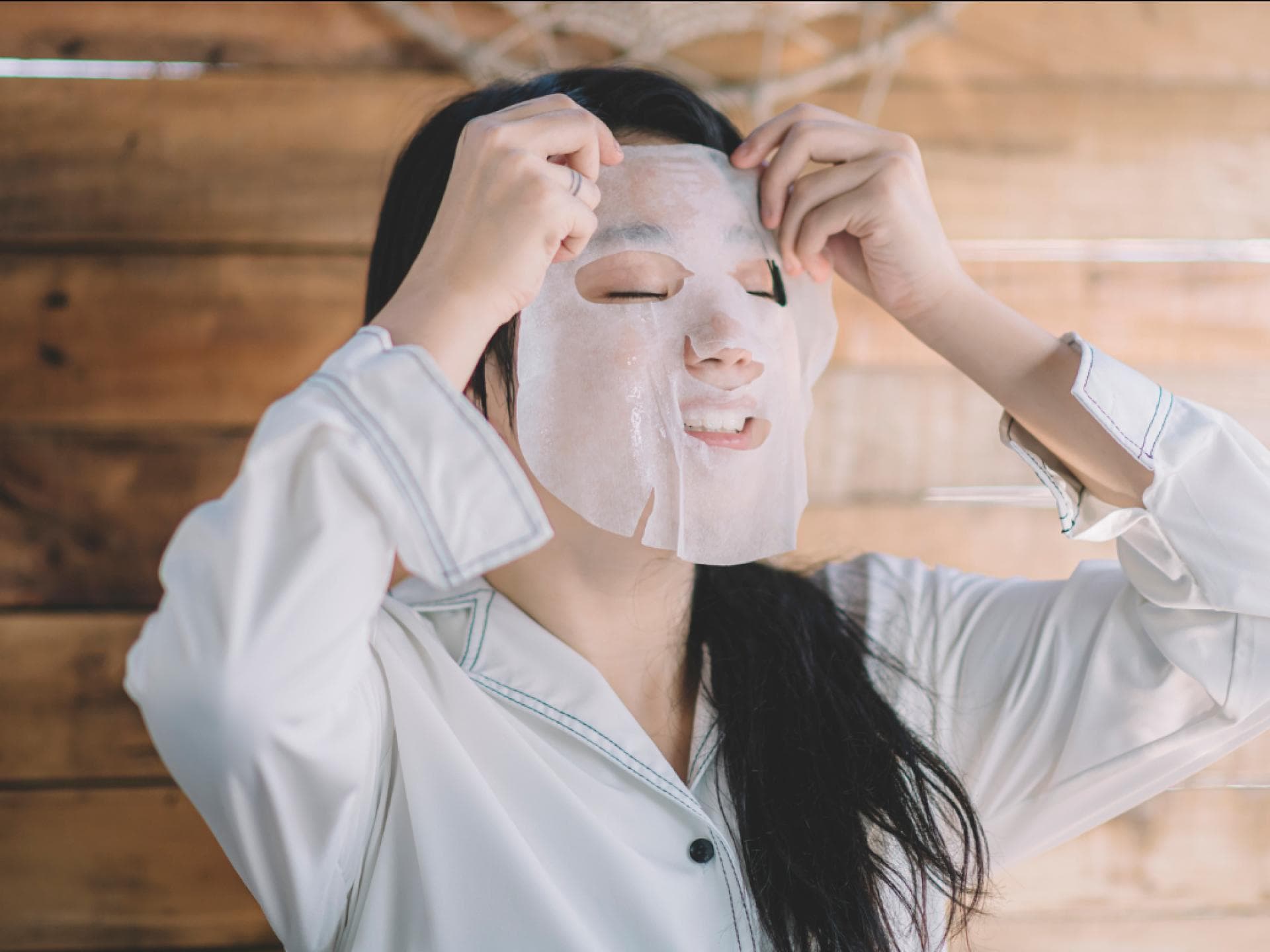 Maske von Daytox mit Vitamin C Frau legt Tuchmaske auf