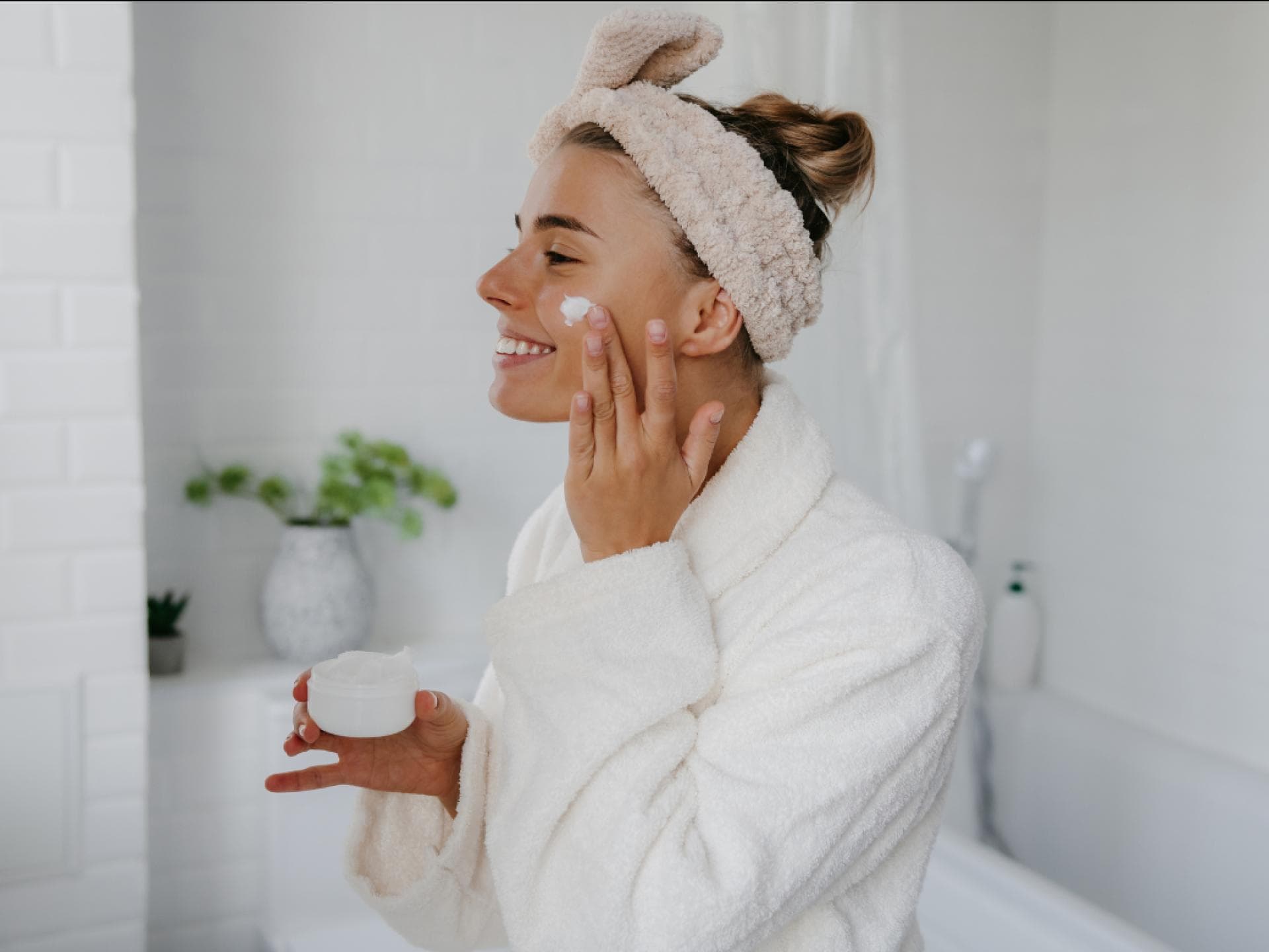 Botox-Creme für weniger Falten Frau trägt Creme auf