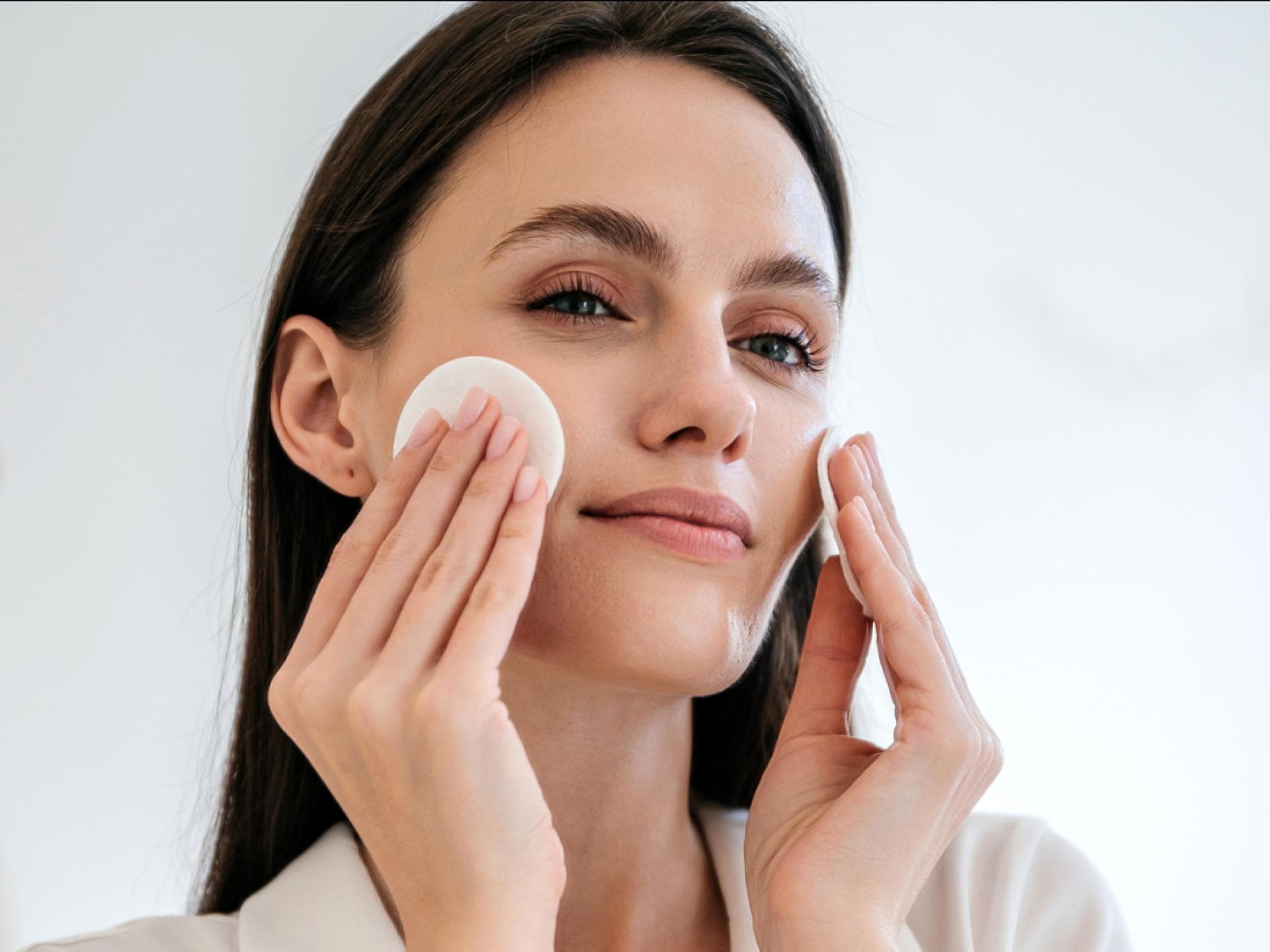Anti-Aging-Toner Frau pflegt Haut mit Wattepads