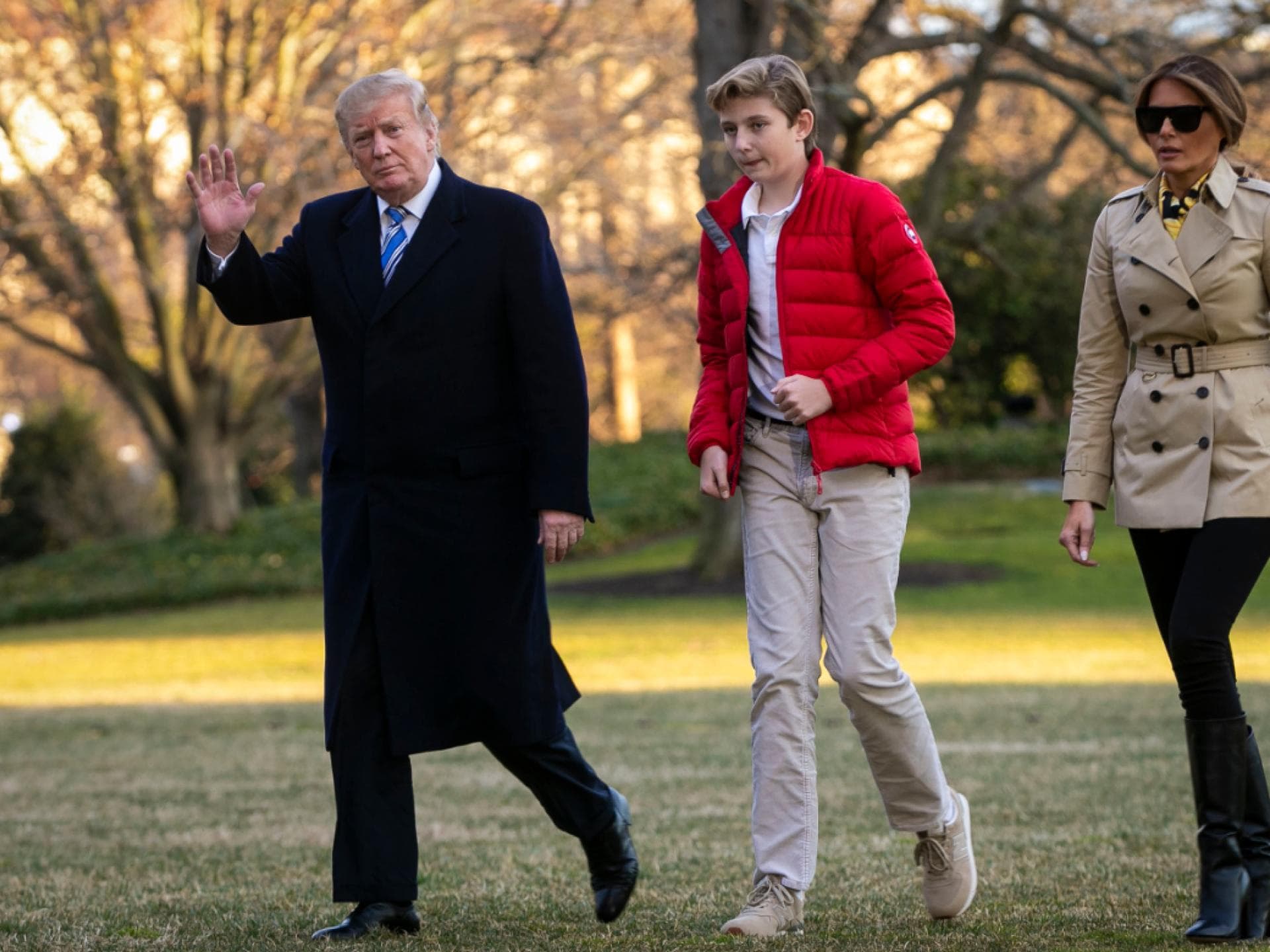 Donald, Barron und Melania Trump spazieren über eine Wiese