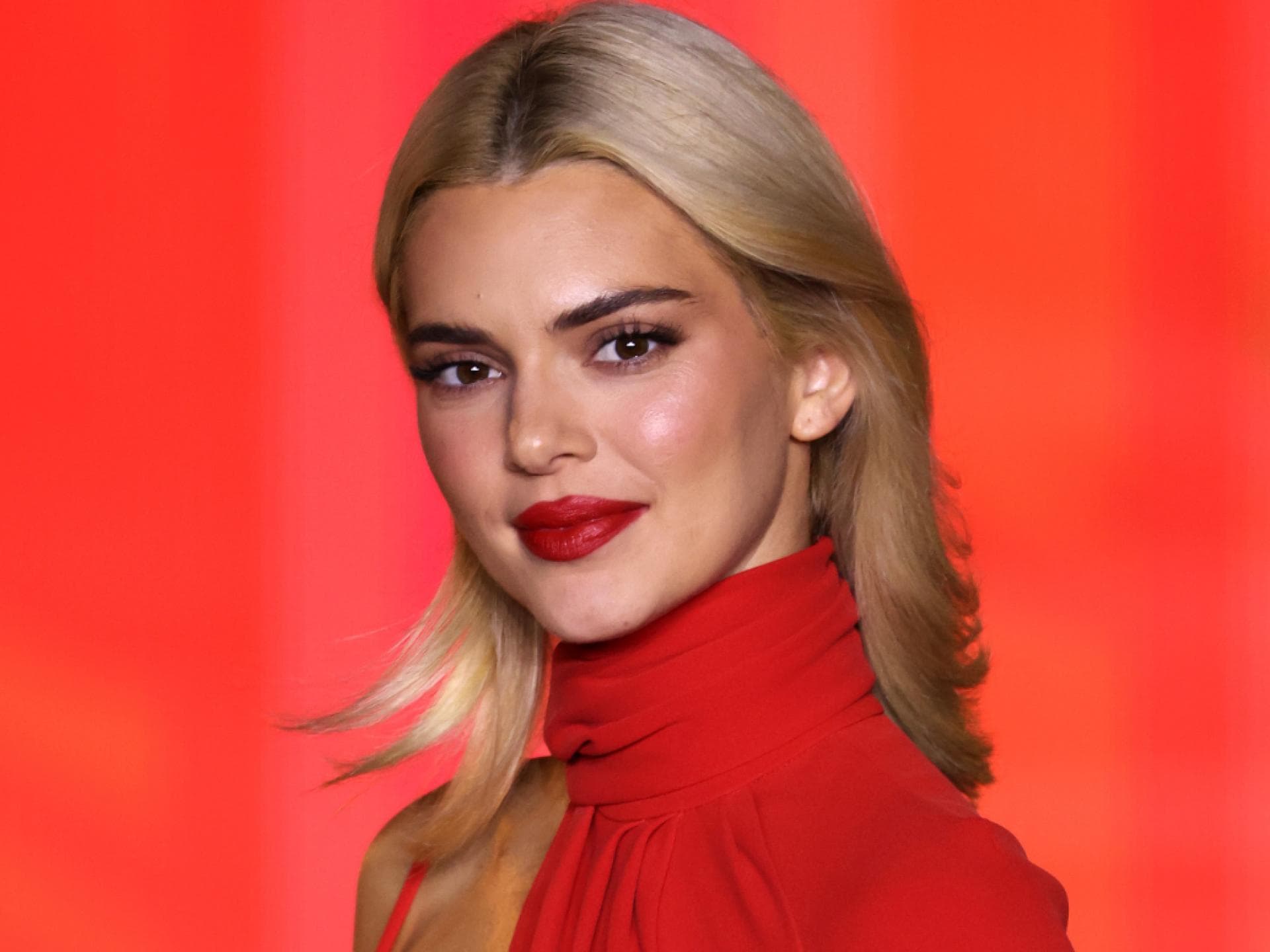 kendall jenner make-up kendall jenner mit blonden haaren vor rotem hintergrund