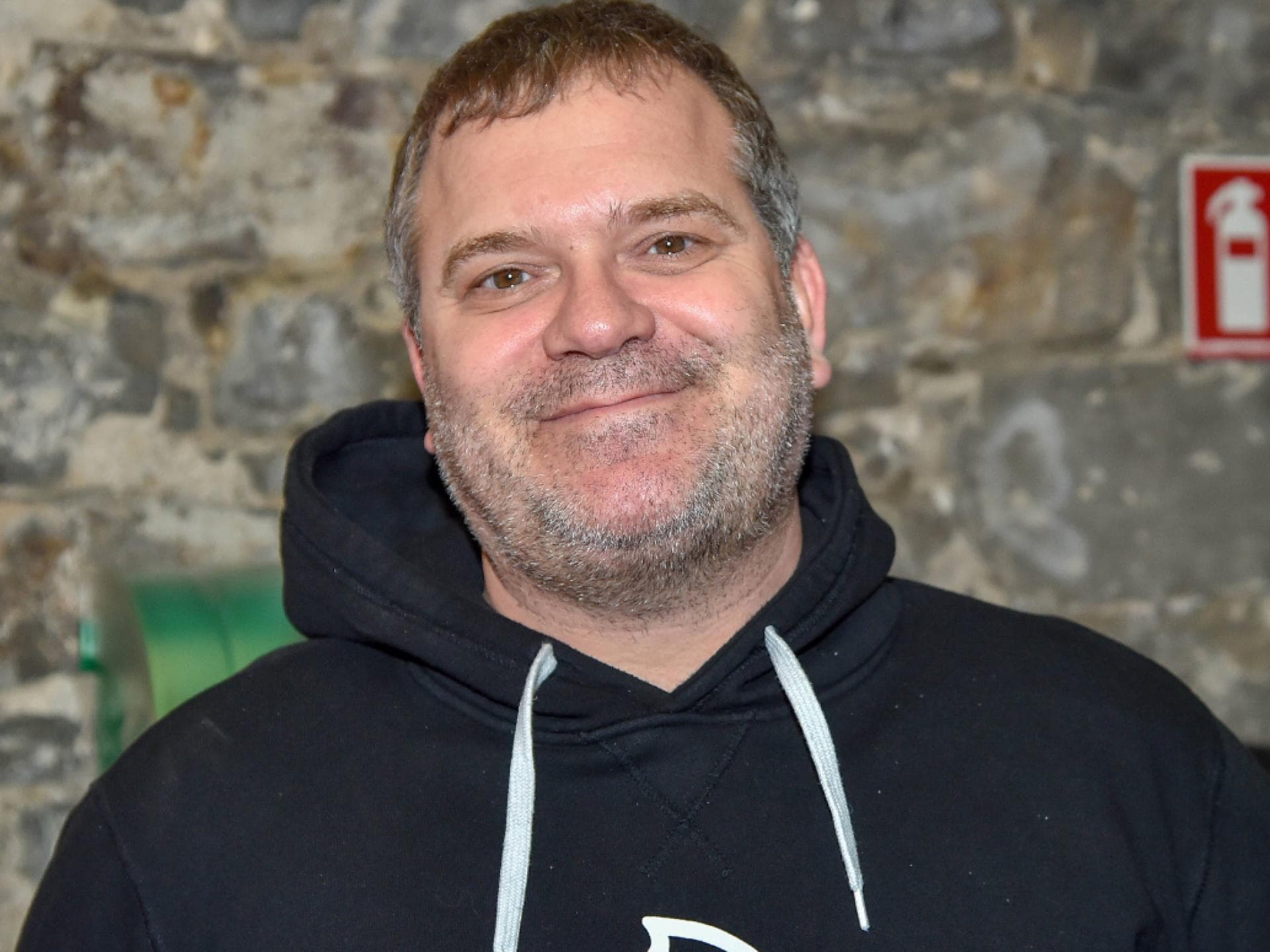 Elton ohne Brille vor Wand
