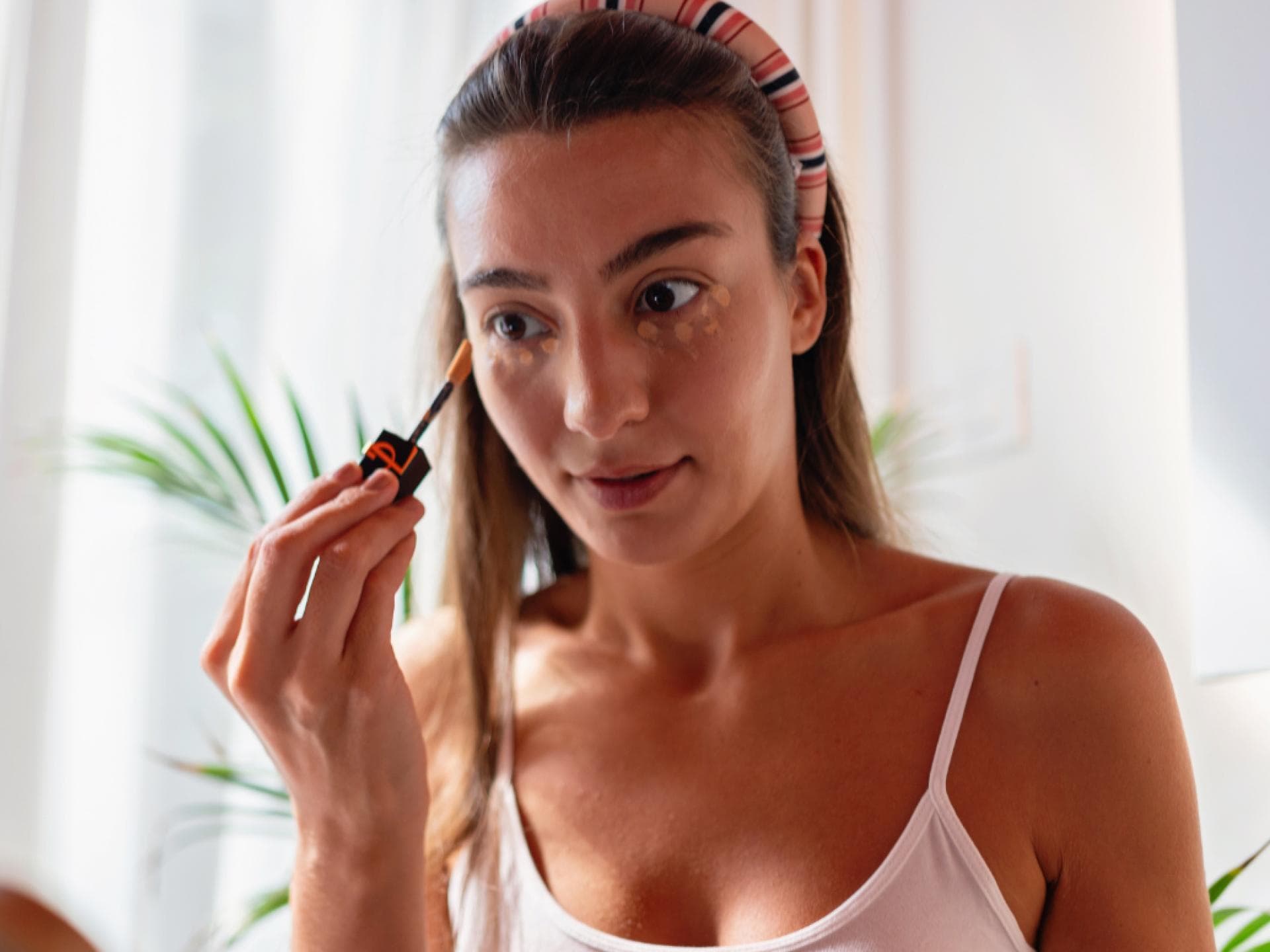 Concealer TikTok-Hype Frau verwendet Concealer vor Spiegel