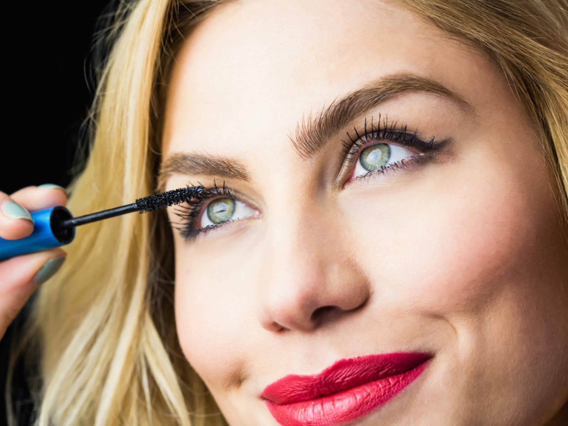 Wimpern anmalen Frau mit Mascara für Volumen