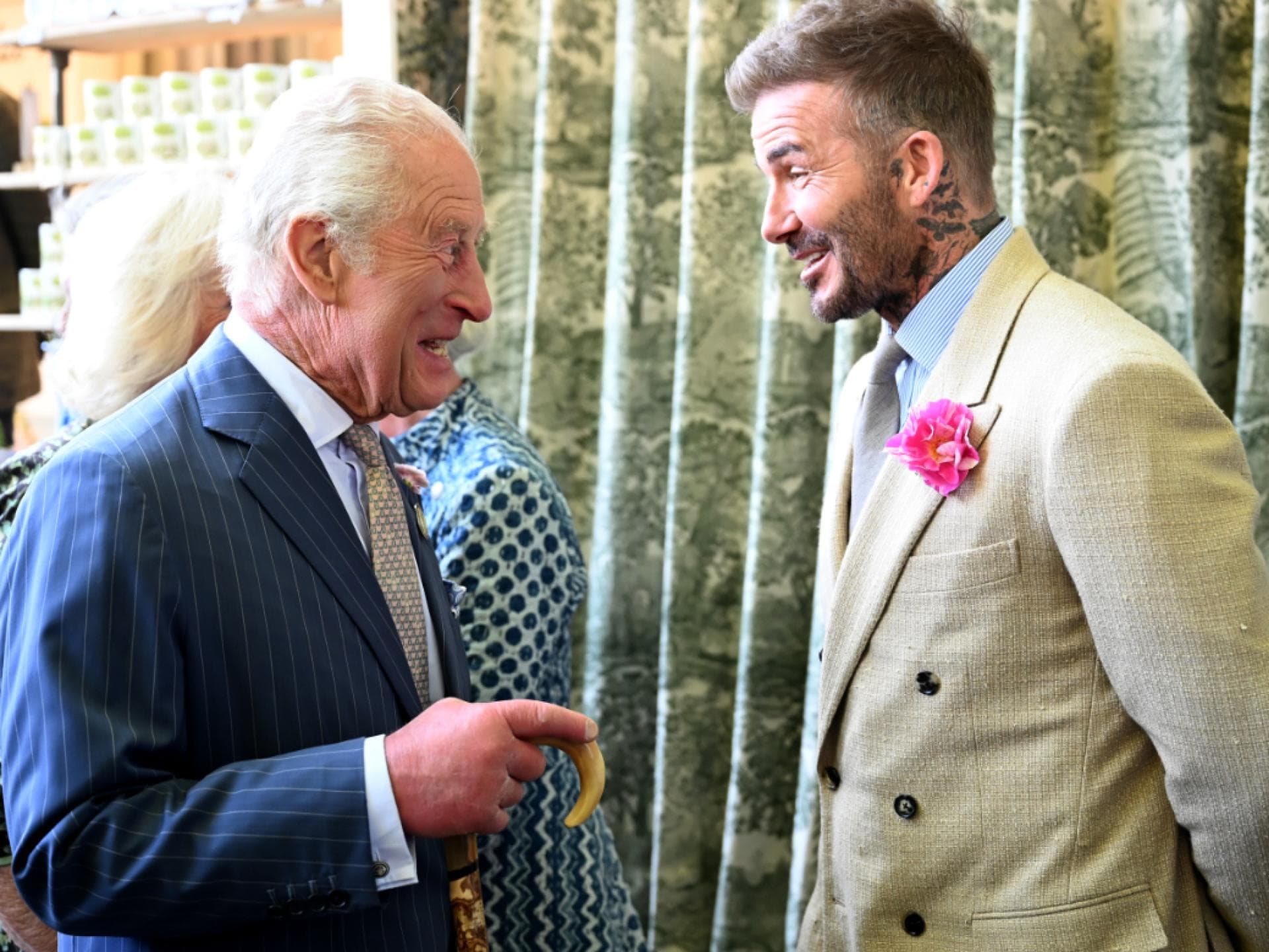 König Charles und David Beckham stehen sich gegenüber und lachen