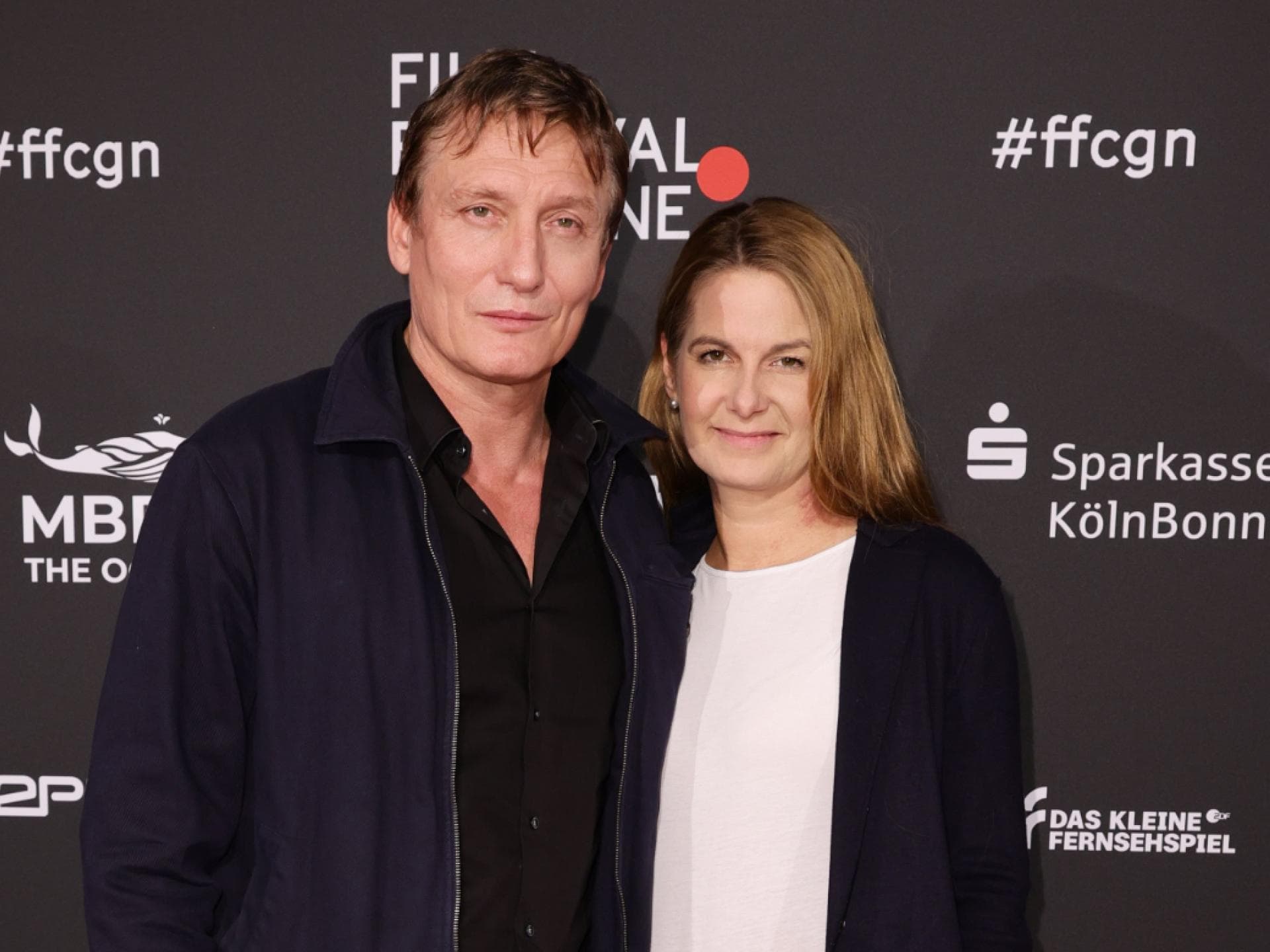 Oliver Masucci und Tanit Koch posieren zusammen