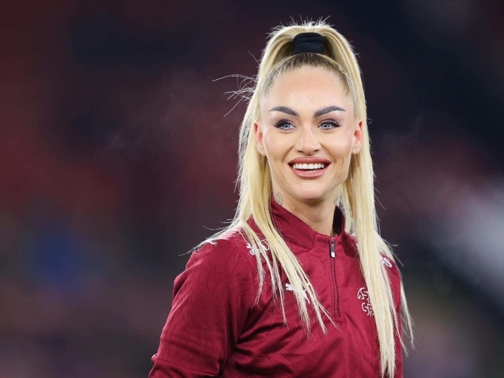 Alisha Lehman mit hohem Zopf, lacht und guckt zur Seite
