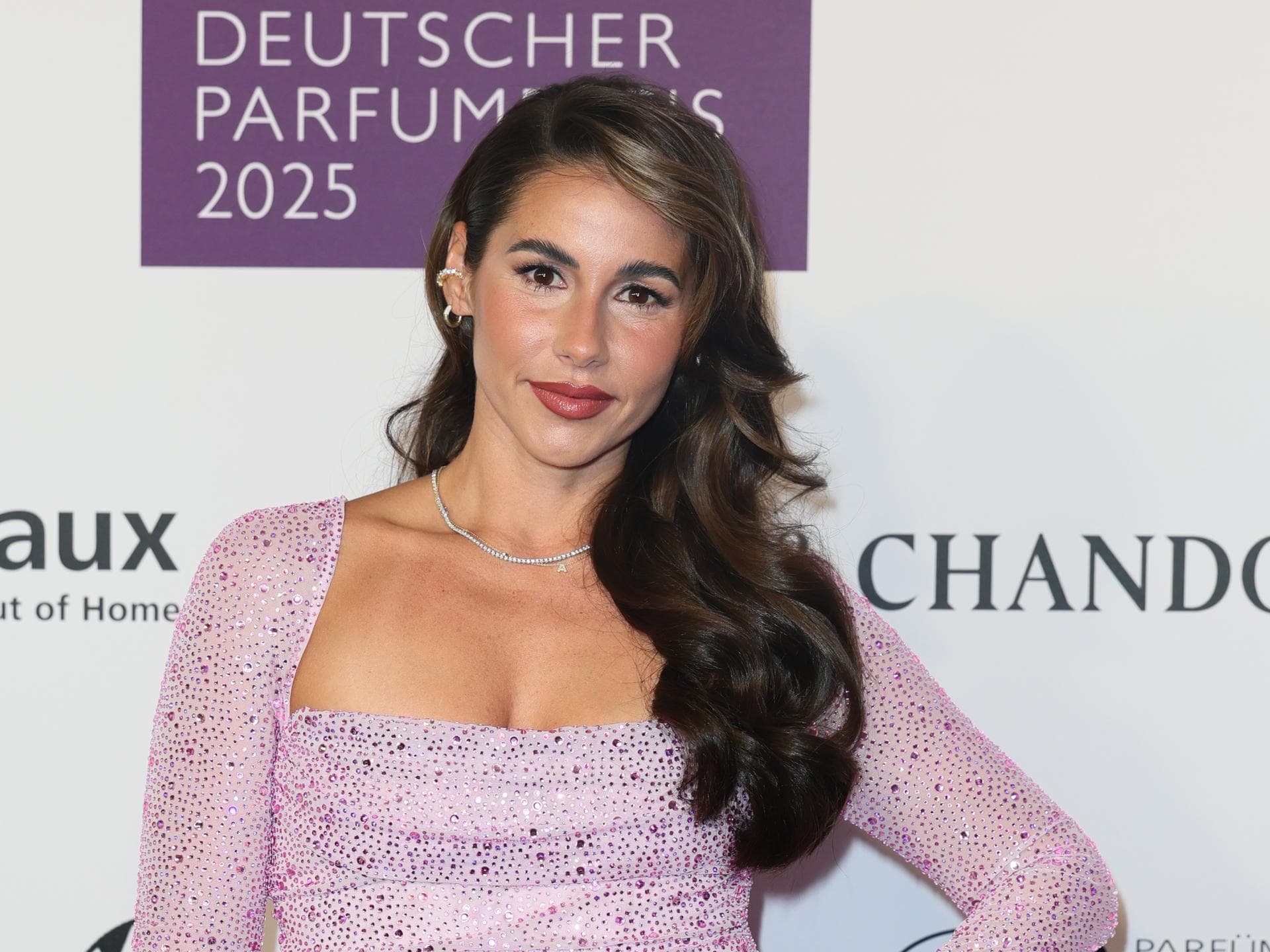 Sarah Engels im lila Glitzerkleid, lächelt leicht