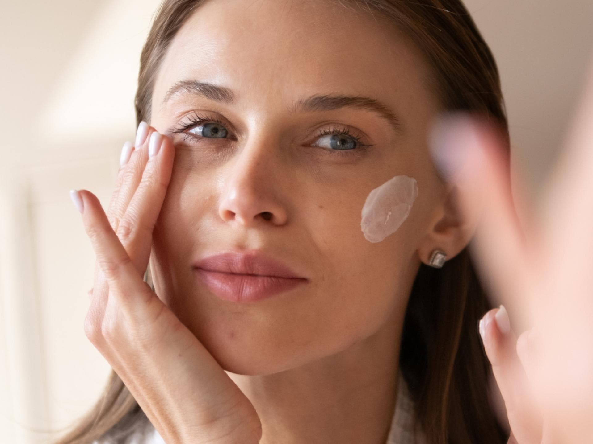 Anti-Aging-Creme TikTok Frau mit Creme auf Wange
