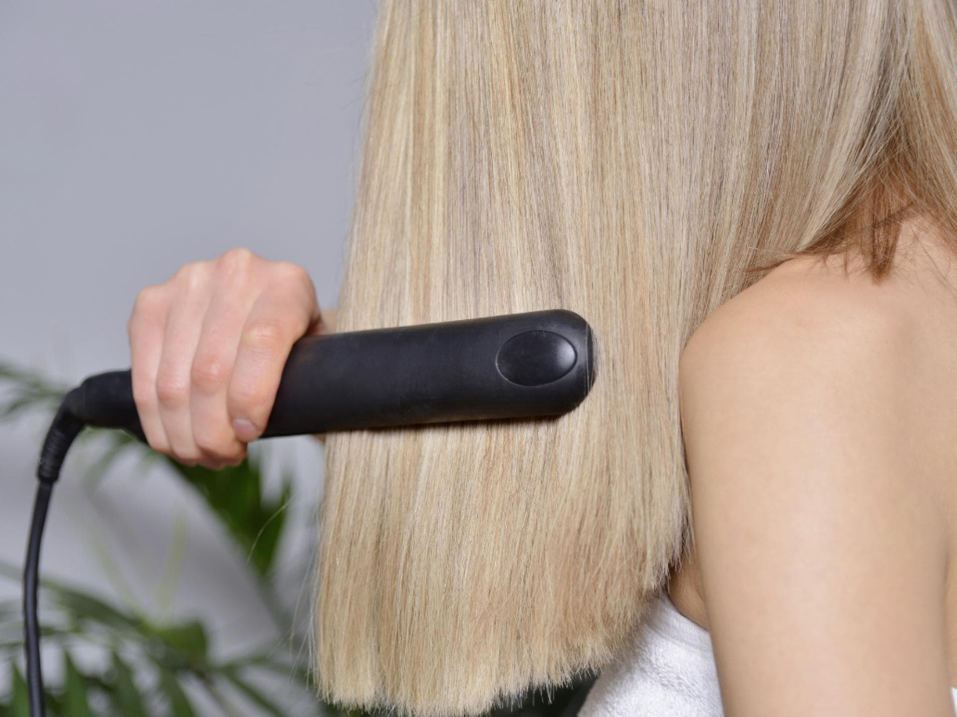 Glätteisen Dyson Frau glättet Haare