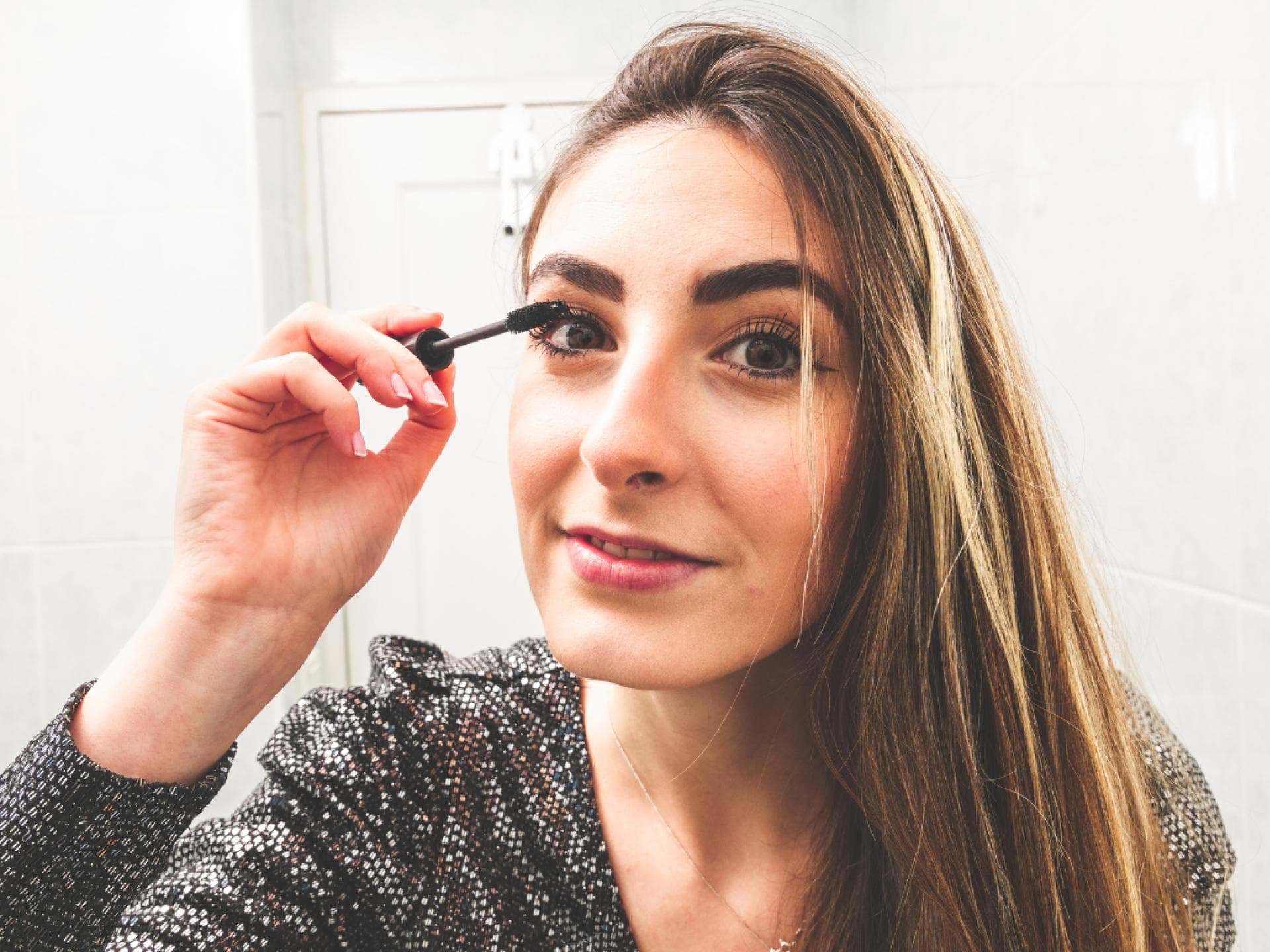 Mascara wie Serum Frau trägt Mascara auf