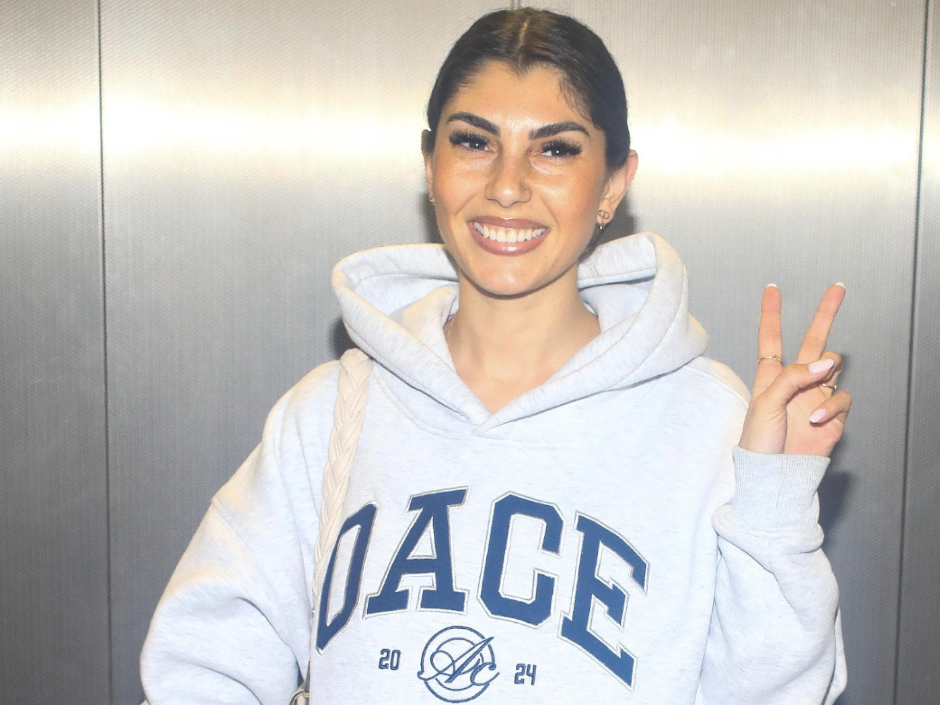 Yeliz Koc zeigt Peace-Zeichen und lacht