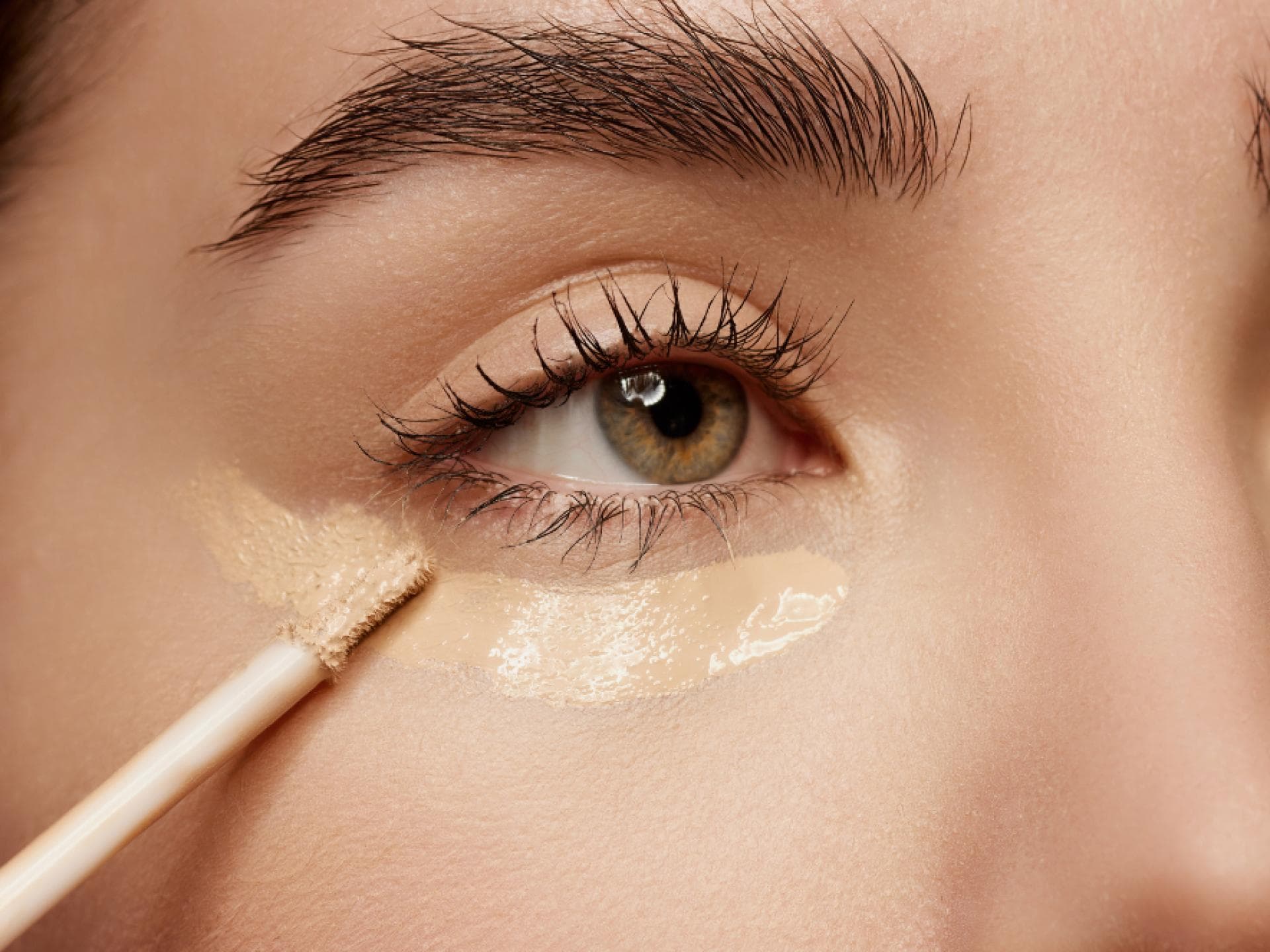 Frau trägt Concealer auf