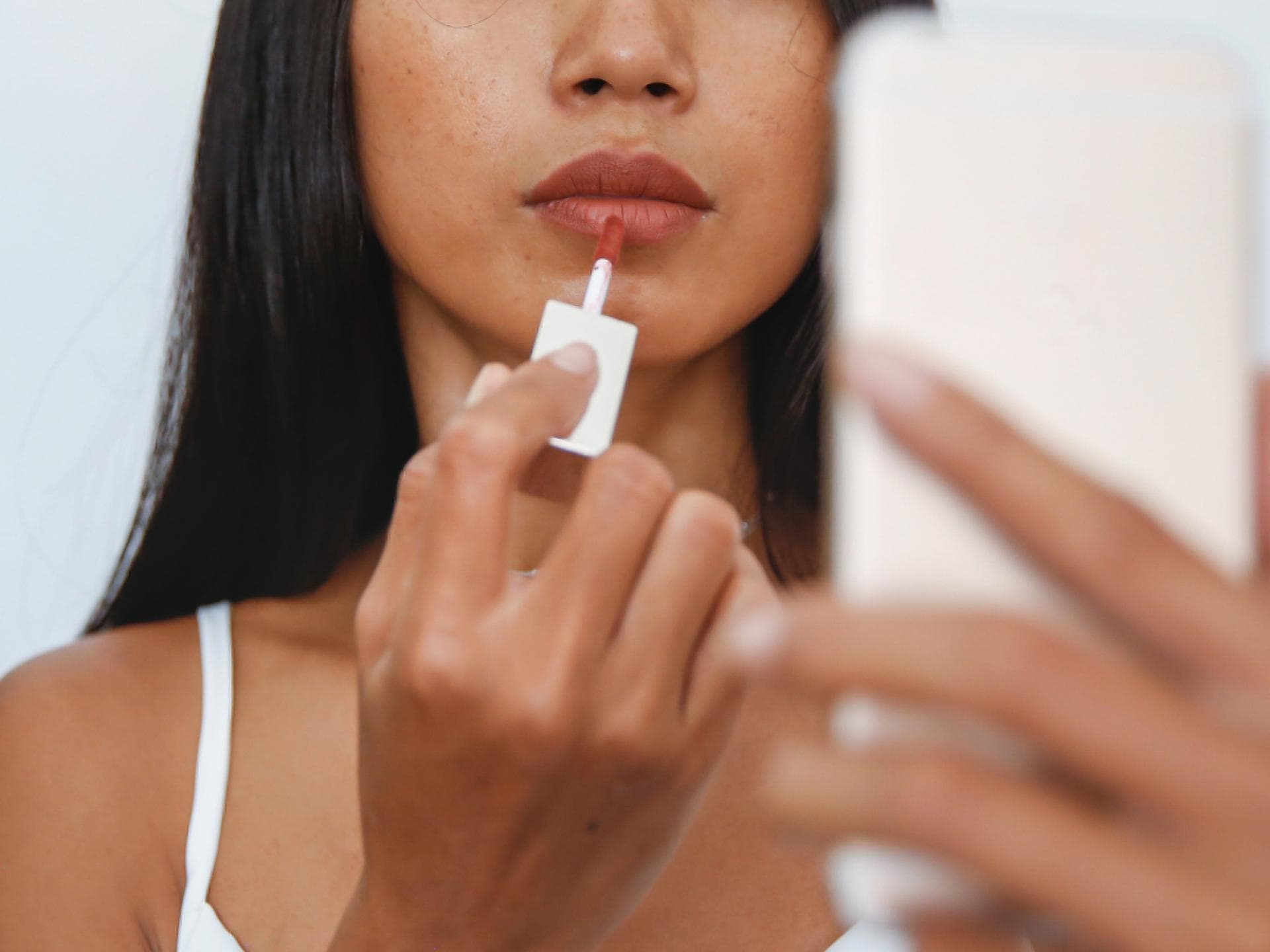 Frau mit Lippenöl aus Drogerie