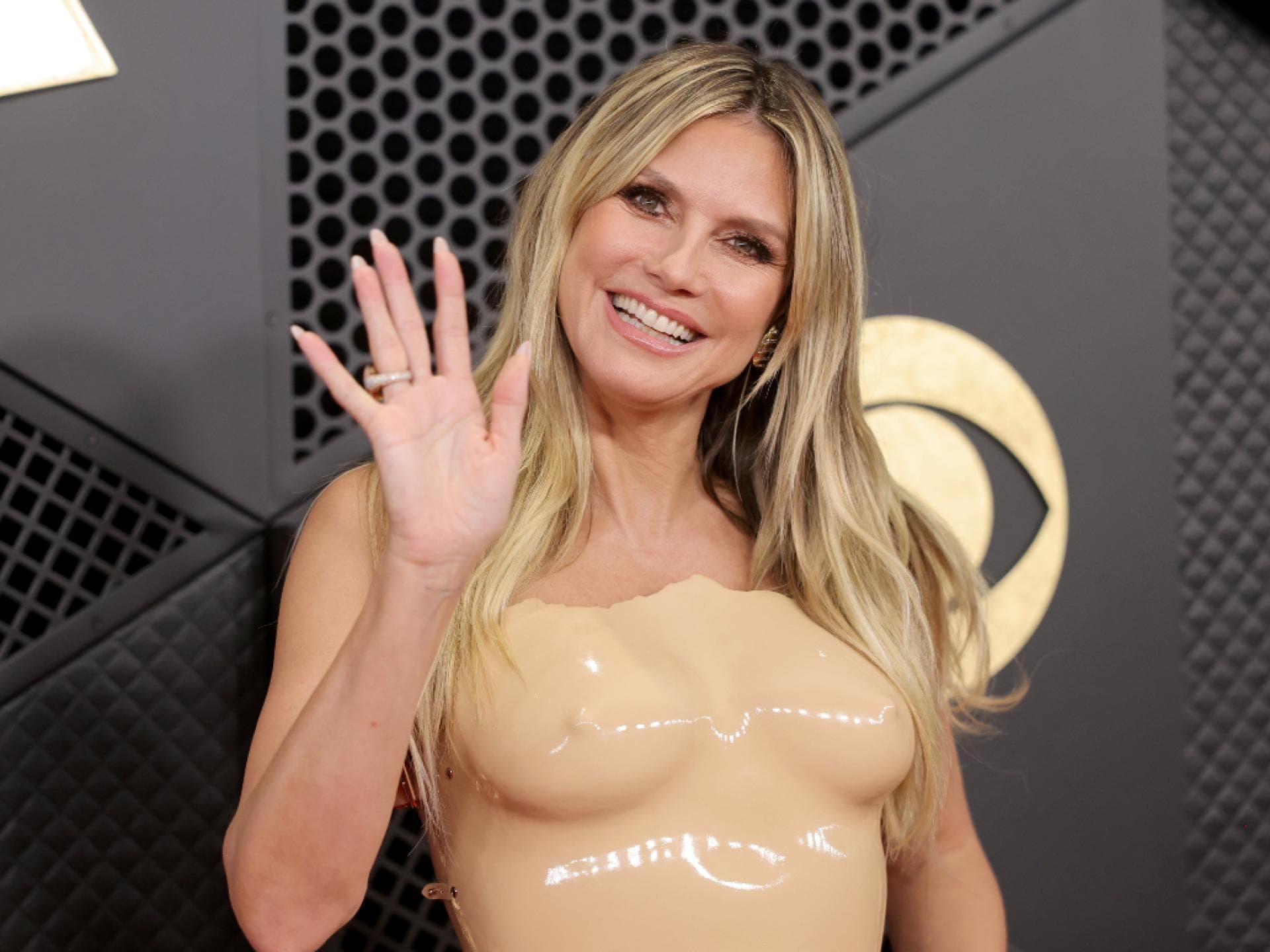 Heidi KLum winkt und lächelt im Nackt-Kleid