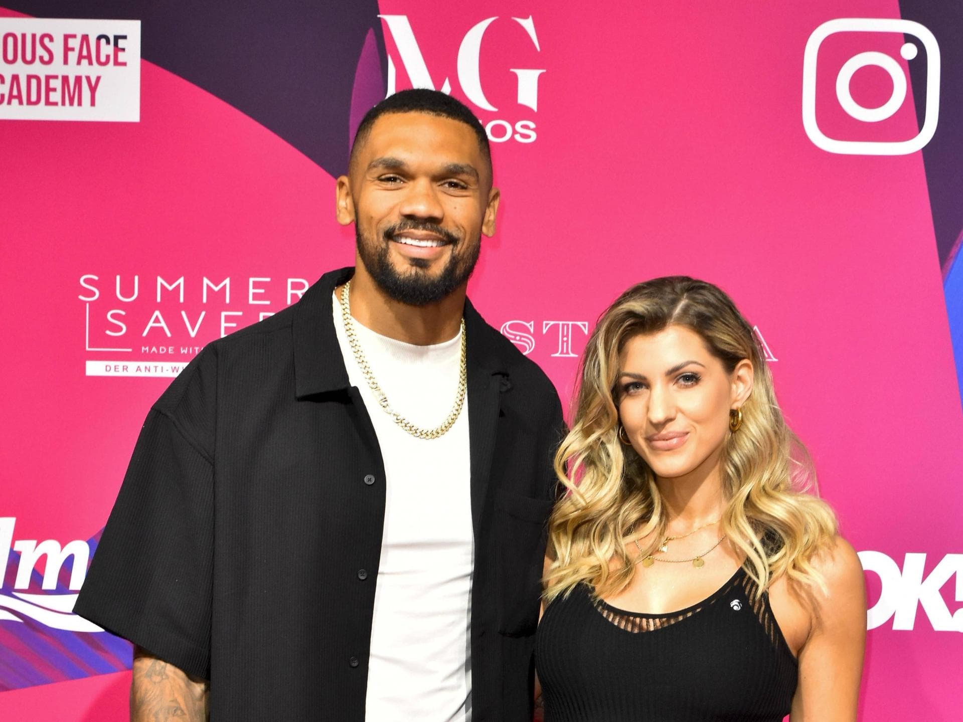 Dominic und Sarah Harrison vor einer pinken Wand