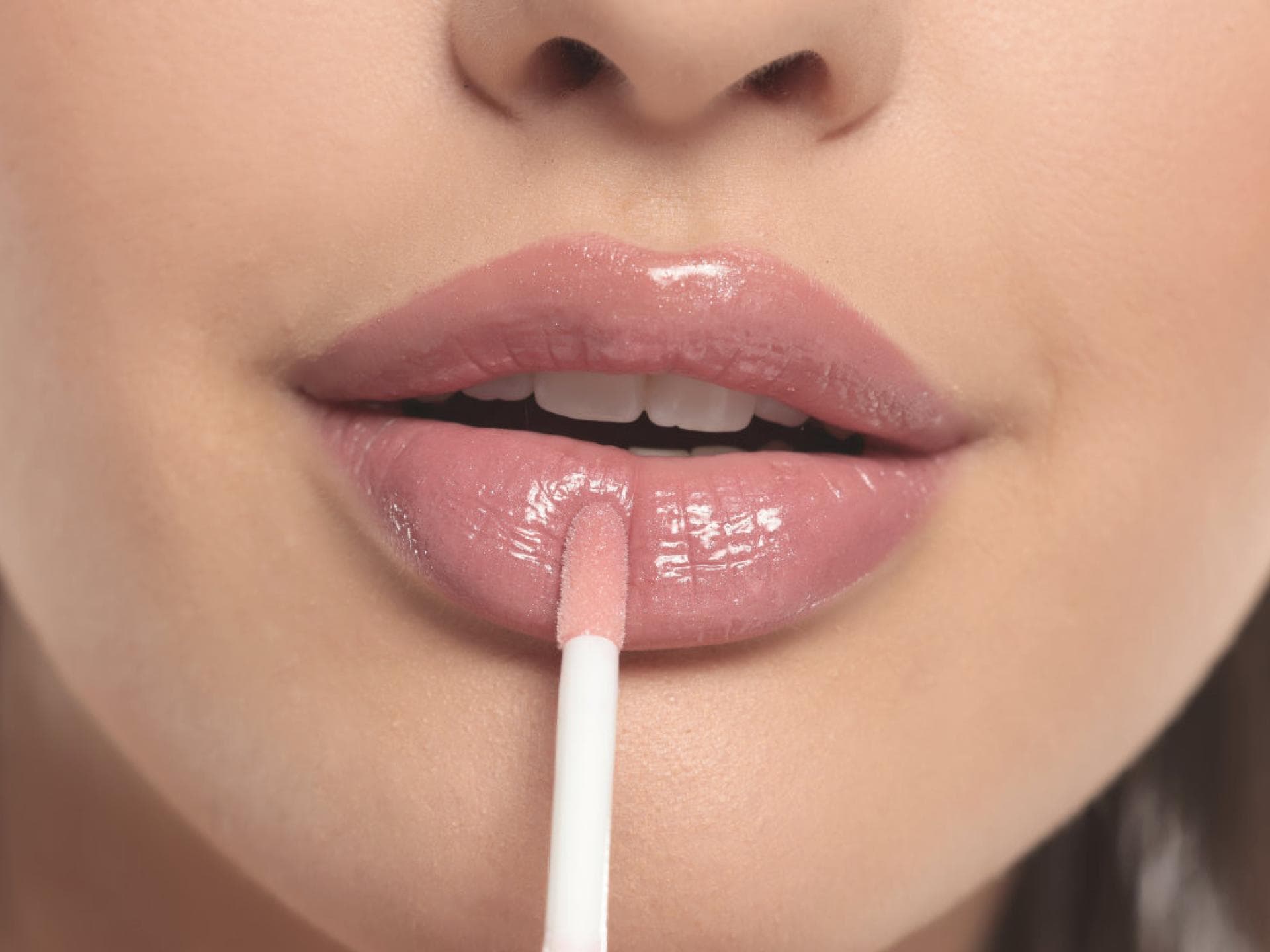 Frau trägt Lipgloss auf