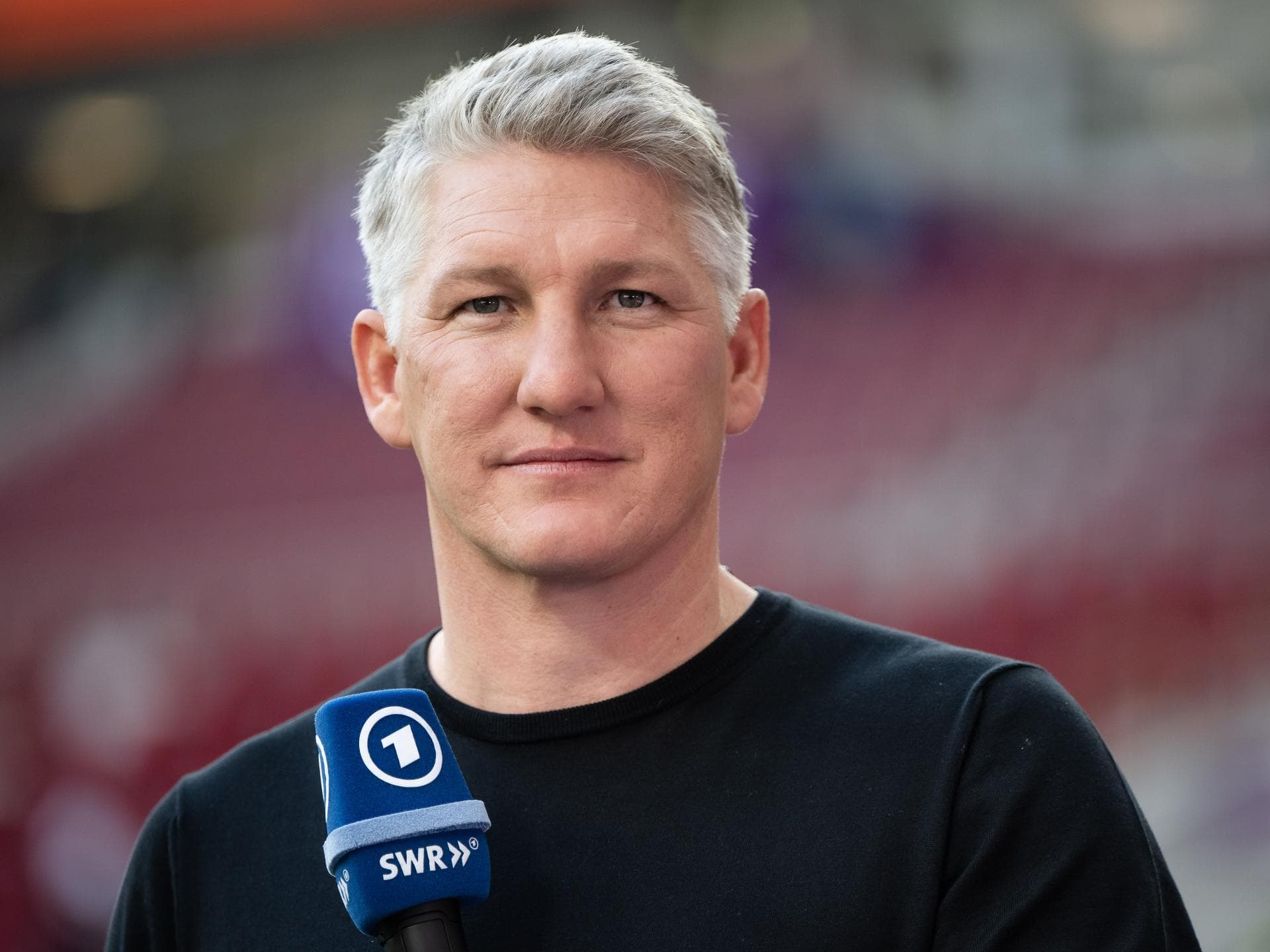 Bastian Schweinsteiger mit Mikrofon in der Hand
