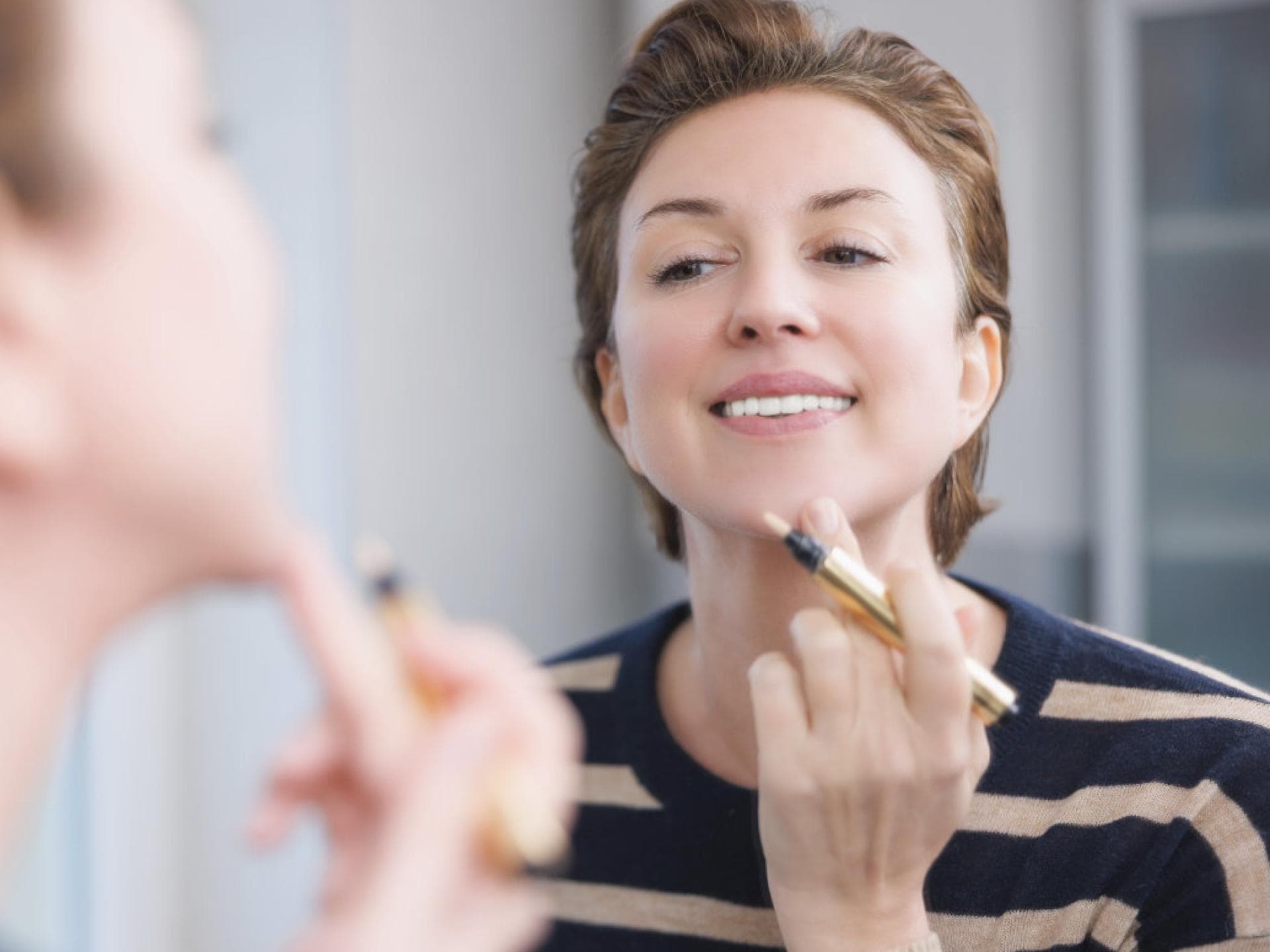 Frau trägt Concealer auf