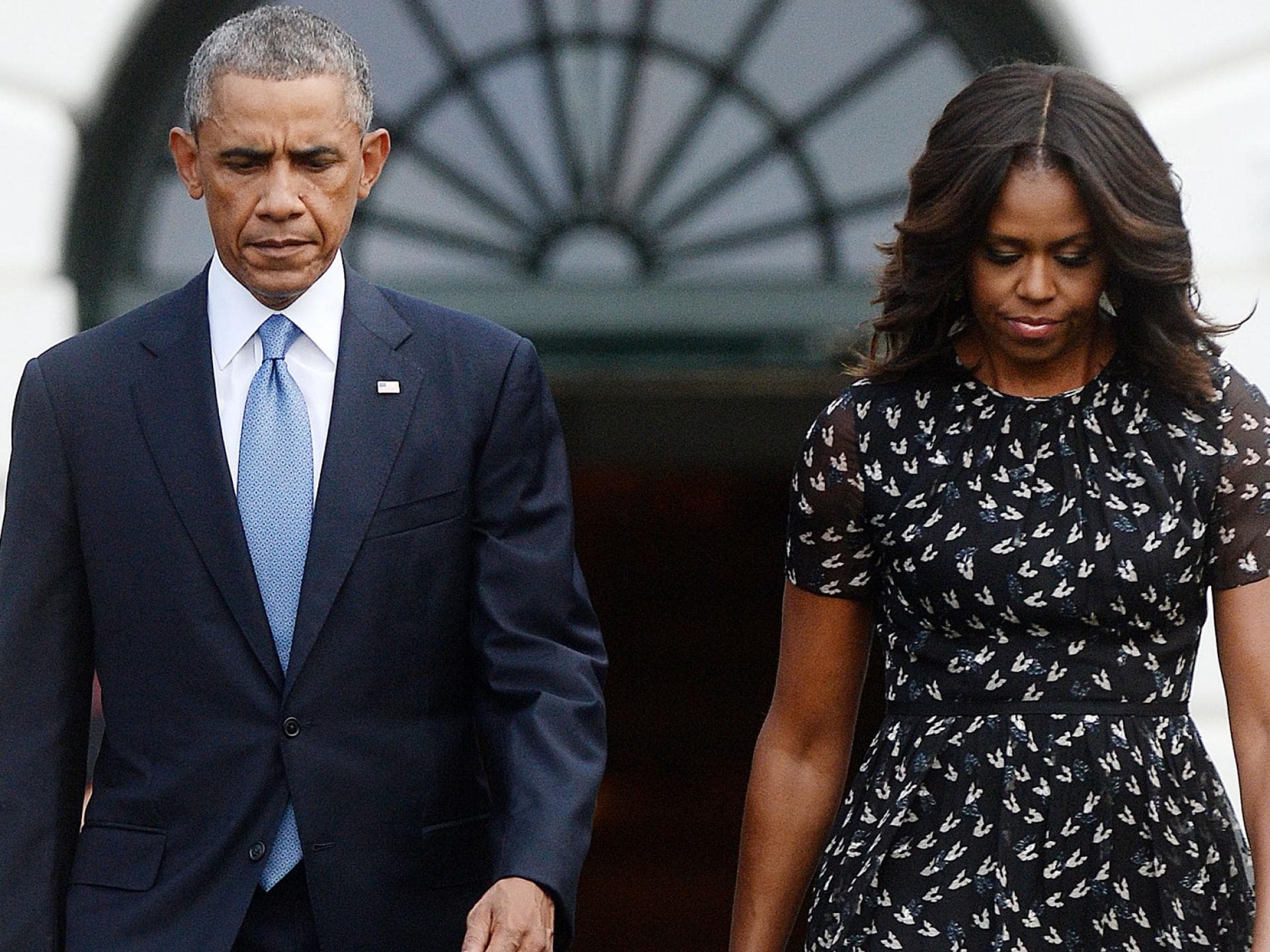Barack und Michelle Obama gucken nach unten