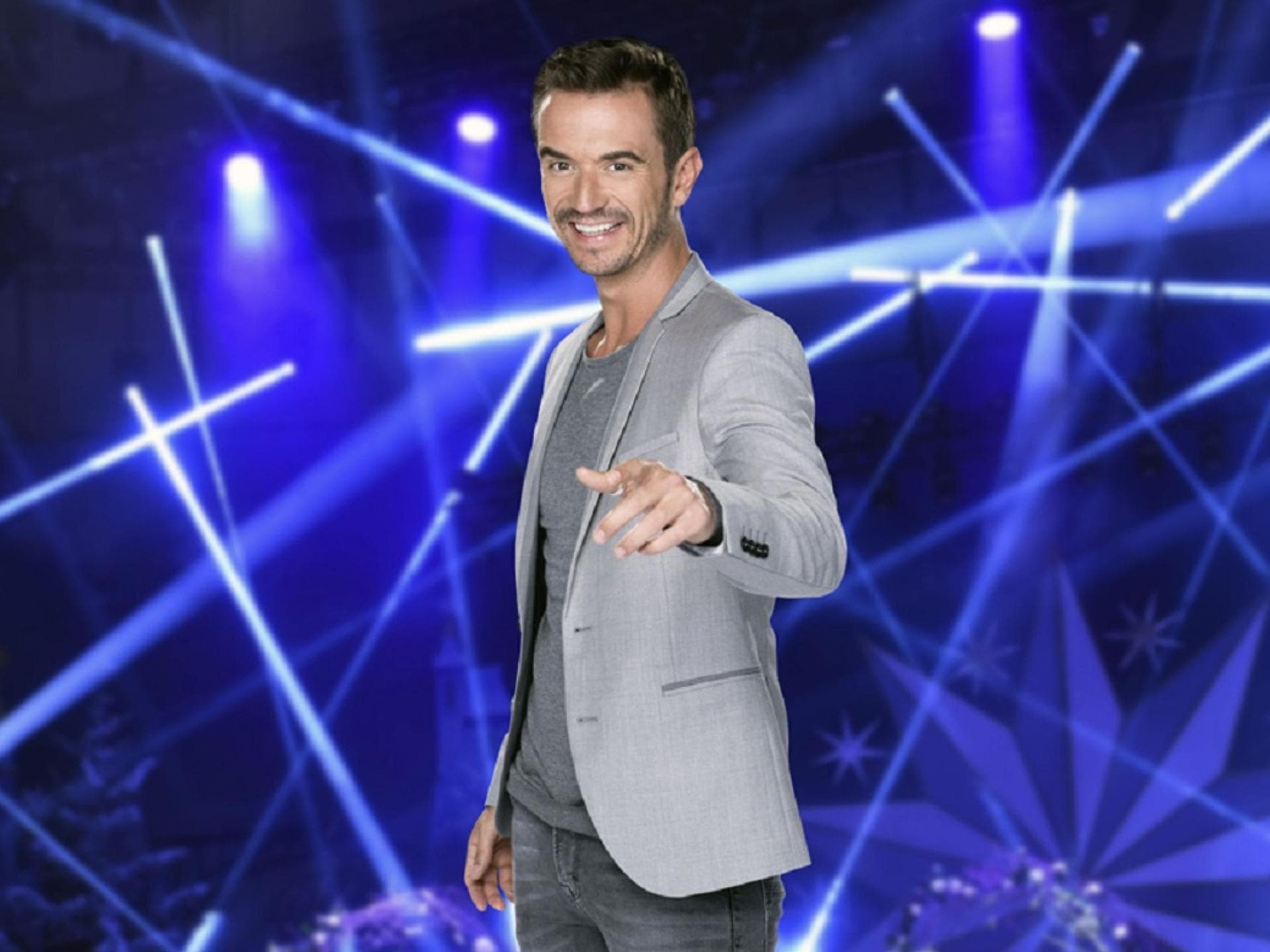 Florian zeigt lächelt mit einem Finger in die Kamera.