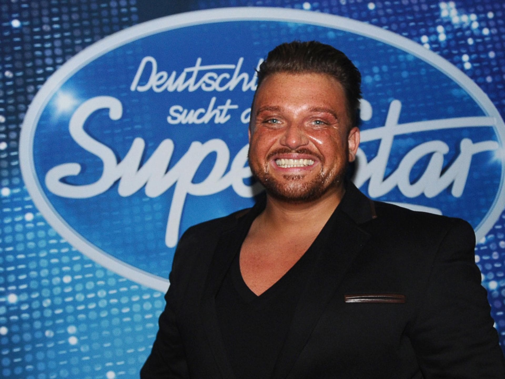 Menowin Fröhlich vor dem DSDS-Logo