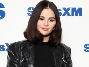 Selena Gomez vor weißer Wand mit Schrift