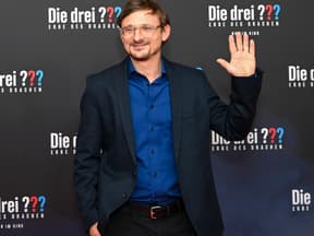 Florian Lukas lacht und winkt